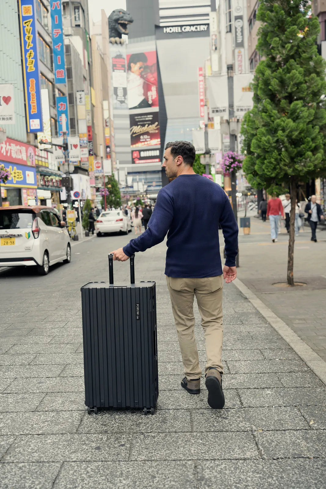 A man wheels the Hades range case down a Tokyo street