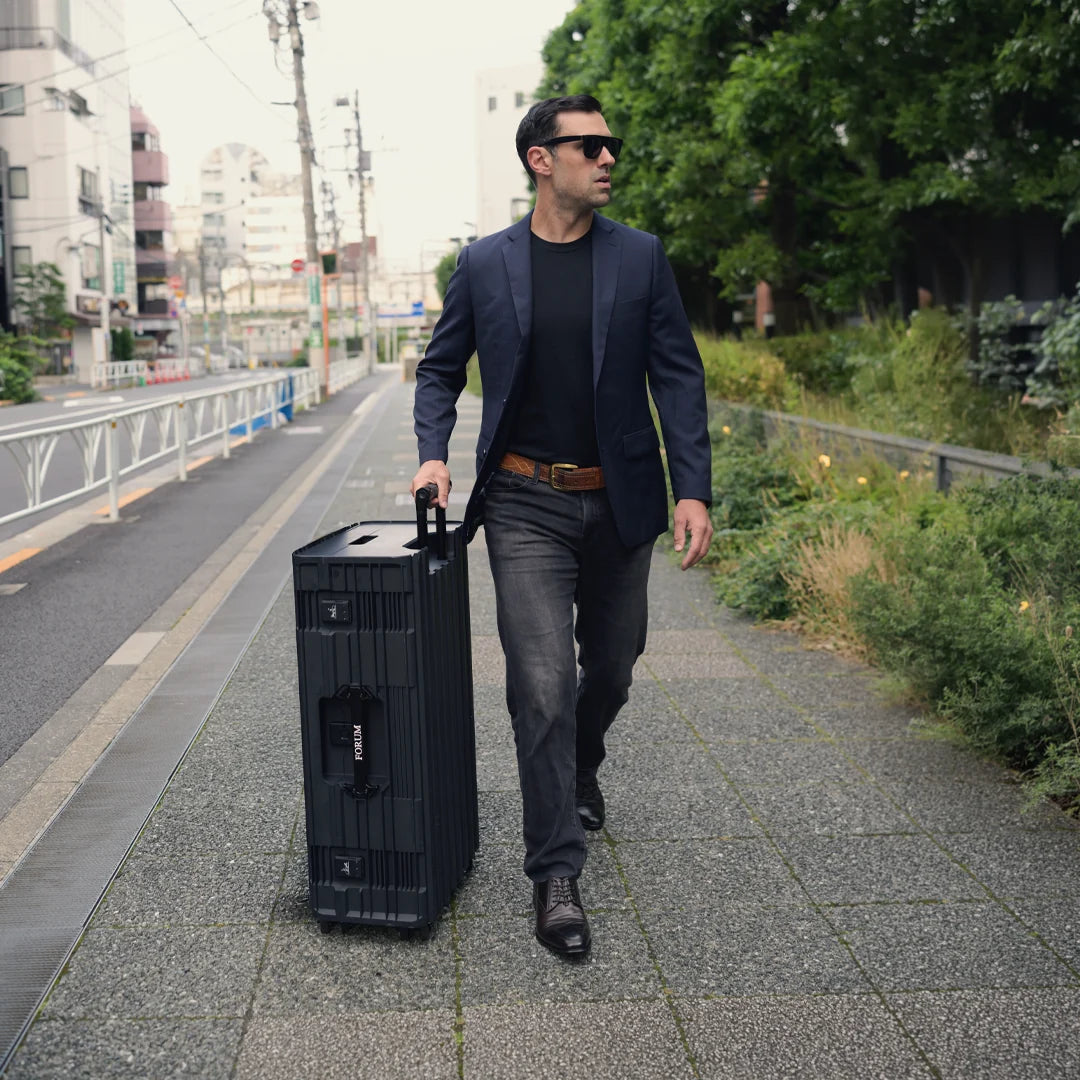 A man wheels the Hades case along a tree-lined street