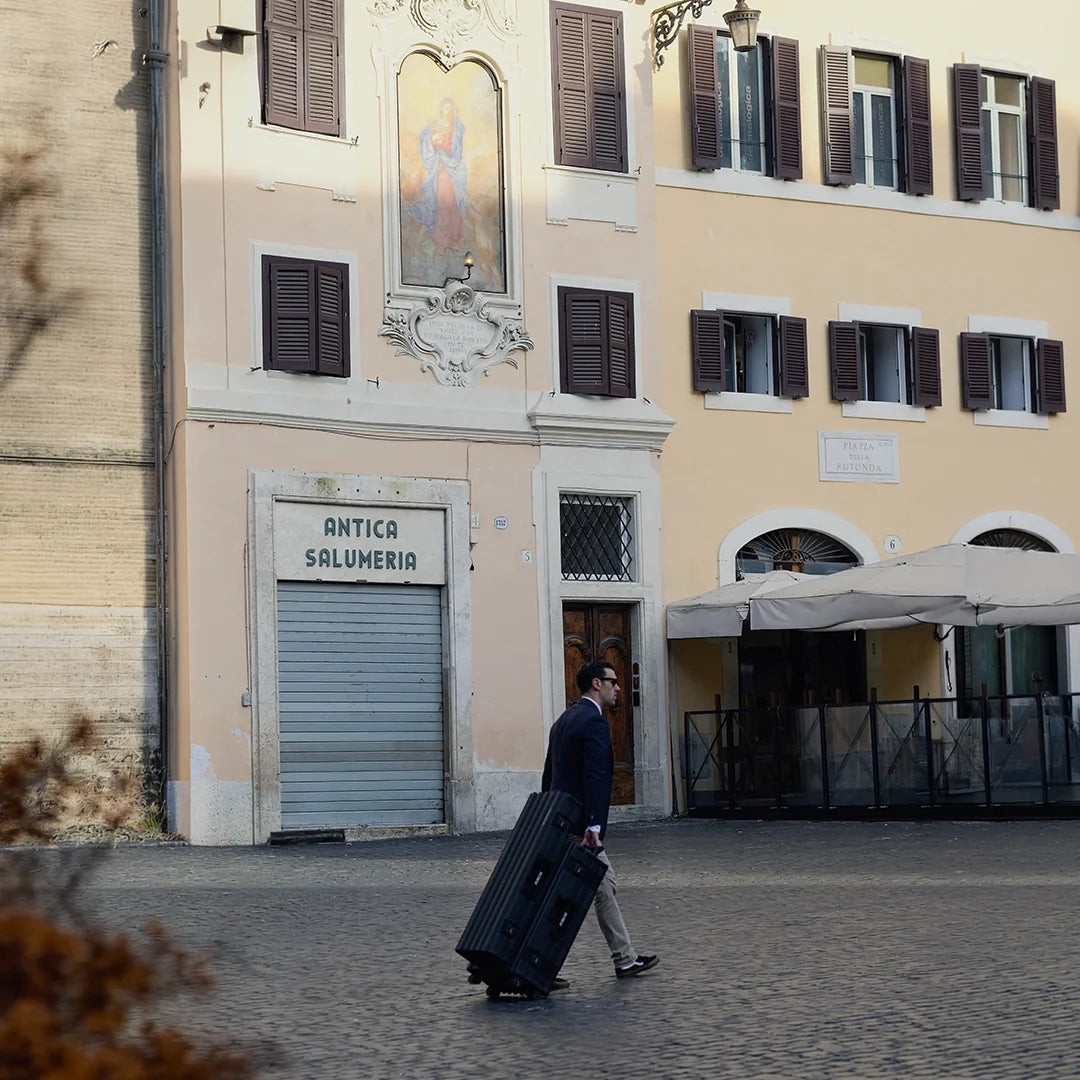 A man wheels the Hades case across a small piazza in Rome