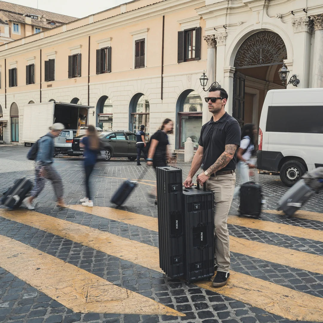 A man stands with the Chariot Bundle on a crossing in Rome as travelers pass