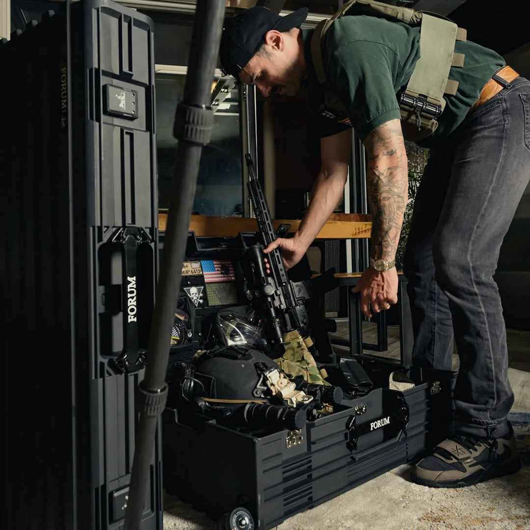 A man loads gear from the open Hades case, Theseus standing beside it